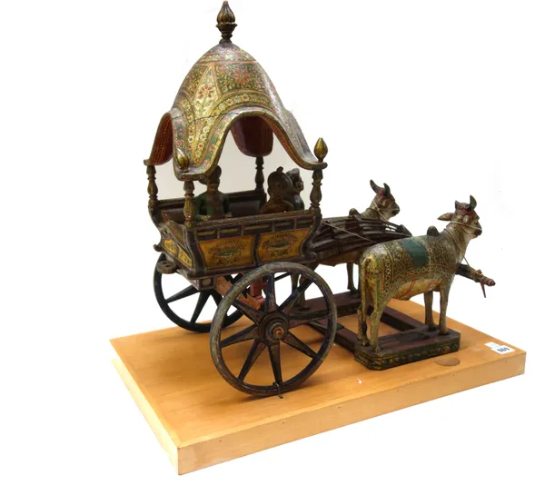 A Kashmiri wooden model of an oxen drawn carriage, early 20th century, polychrome painted on a later wooden plinth 60cm wide.