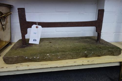 A Victorian cast iron boot scraper of plain rectangular iron form, mounted in a later stone plinth, 63cm wide.