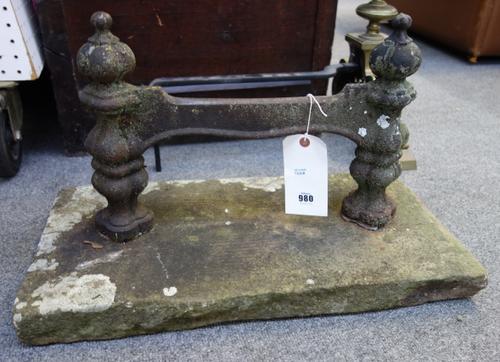 A pair of Victorian cast iron boot scrapers, each foliate pillar of quadralobe form united by a flat foot plate on a rectangular stone plinth, 60cm (2