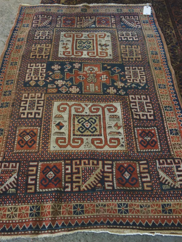 A Karachor Kazak rug, Caucasian, the indigo field with two ivory squares, a madder central cross, hook motifs, a star border, 174 x 117cm.