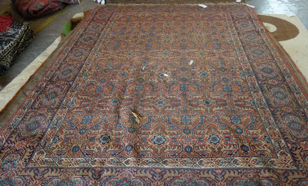 A Tabriz carpet, the madder field with an allover trellis design, an indigo cartouche border, 316 x 230cm.