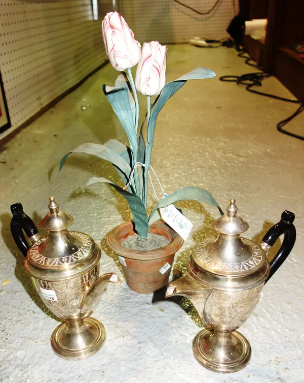 A silver plated Continental coffee pot, a similar jug and a painted metal ceramic flower in a pot. CAB