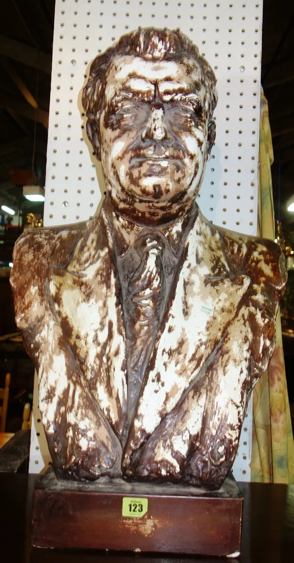 A patinated plaster bust, late 20th century, depicting a gentleman in a blazer, shirt and tie, atop a rectangular plinth, 70cm high.   C6