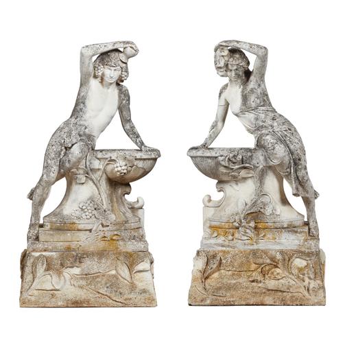 A pair of reconstituted stone figures, both cast as a semi-clad male and female drinking from a well, each on a floral moulded square base, 64cm wide