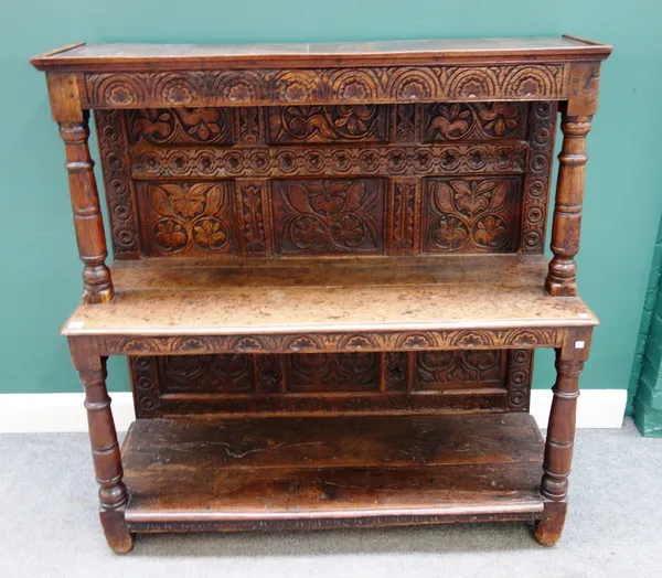 A made-up 17th century oak buffet, with carved panel back, on turned supports, 127cm wide x 130cm high x 46cm deep.