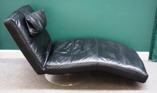Habitat; a 20th century black leather upholstered chaise longue, on a circular polished steel base, 200cm long x 85cm high.