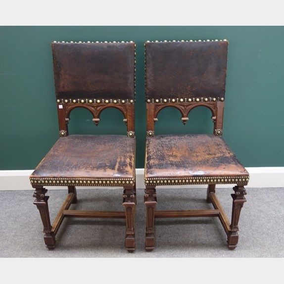 A set of six late 19th century Italian carved walnut square back dining chairs with studded leather upholstery.