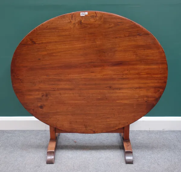 A 19th century Continental walnut wine tasting table, the oval folding top on pair of trestle end standards, 125cm wide x 71cm high x 103cm deep.