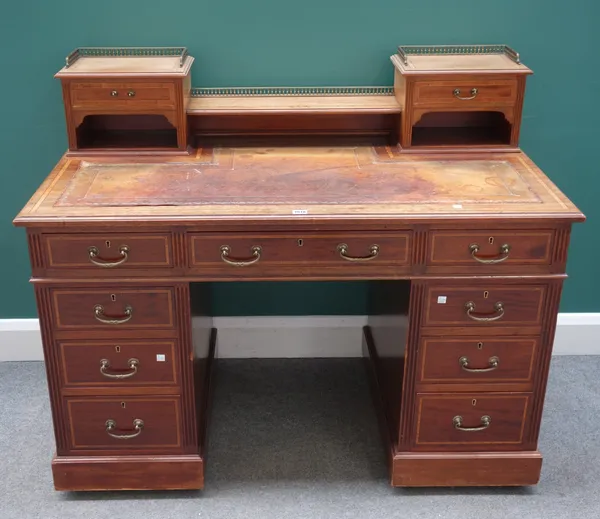 A late 19th century crossbanded mahogany Dickens style pedestal desk, with nine drawers about the knee, 123cm wide x 101cm high x 68cm deep.
