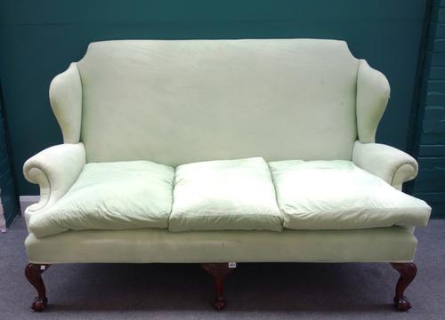A Queen Anne style green wing back sofa on claw and ball feet, 187cm wide x 114cm high x 87cm deep.