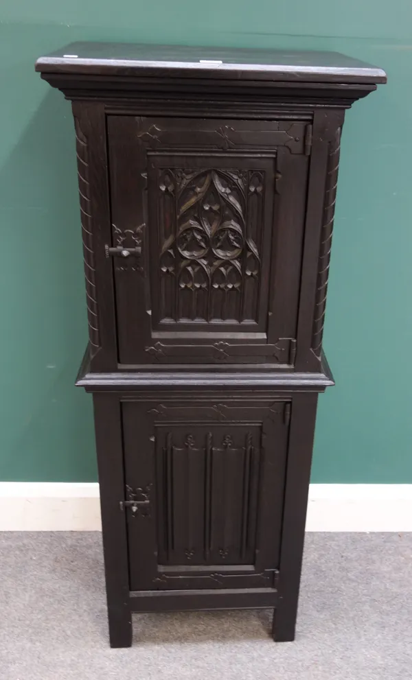 A Gothic Revival ebonised oak double height cupboard with Gothic arch tracery panel door, 50cm wide x 121cm high x 37cm deep.