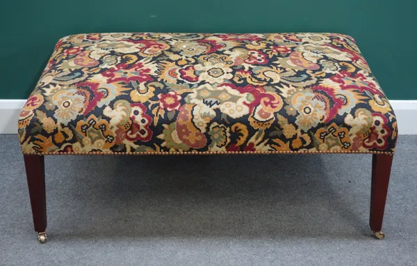 A George III style rectangular footstool with tapestry upholstery on square tapering mahogany supports, 107cm wide x 47cm high x 64cm deep.