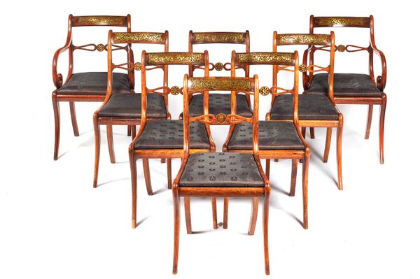 A set of eight George IV inlaid faux rosewood dining chairs with bullseye waist rail on sabre supports, to include a pair of carvers.  Illustrated