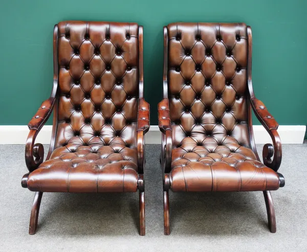 A pair of early 19th century style mahogany framed scroll back open arm easy chairs, with buttoned brown leather upholstery, 65cm wide x 90cm high x 9