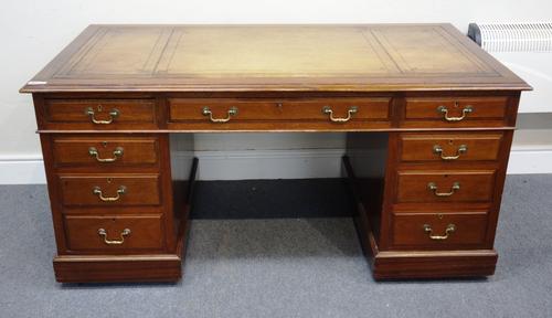 An early 20th century mahogany pedestal desk, with nine drawers about the knee, on a plinth base, 154cm wide x 75cm high x 81cm deep.