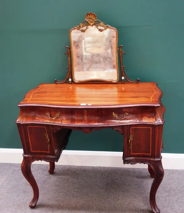 A 19th century continental inlaid rosewood  free standing dressing table of serpentine outline, the gilt metal mounted swing mirror over a pair of fri