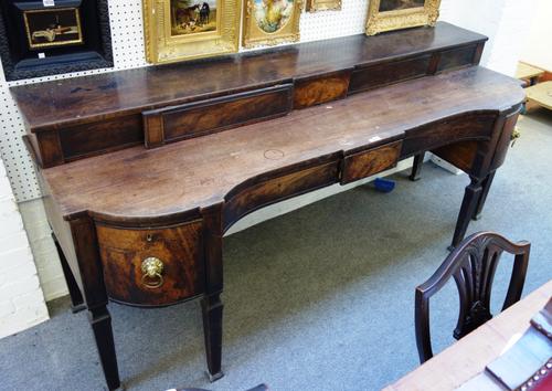 A large George III mahogany sideboard, with stepped ledge back over five concave frieze drawers, on tapering square supports, 228cm wide x 103cm high