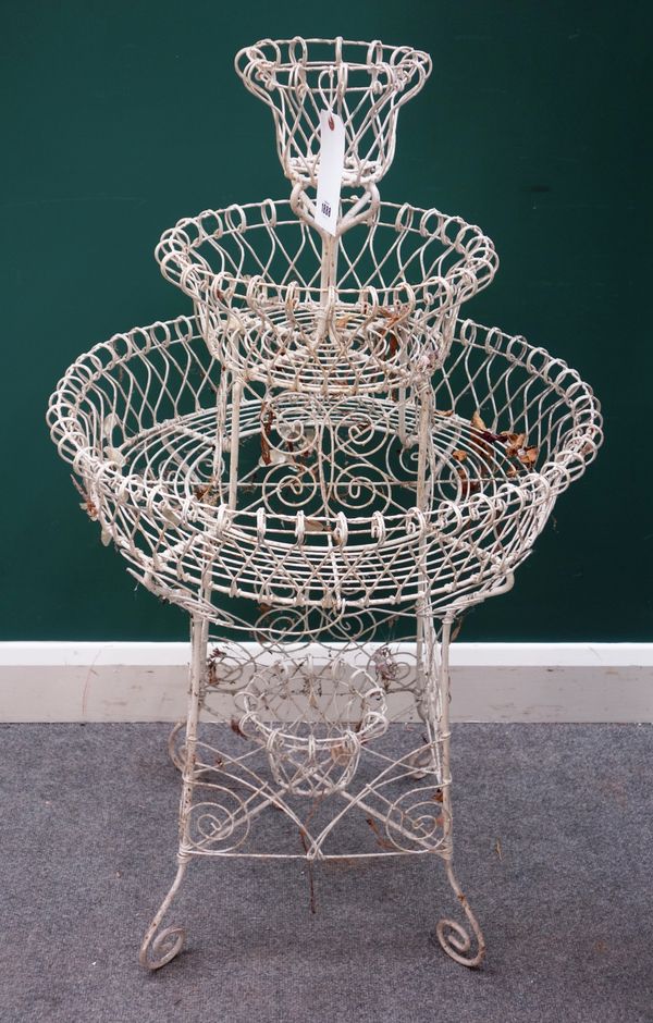 An Edwardian white painted graduated circular three tier wirework plant stand, 65cm wide x 115cm high.