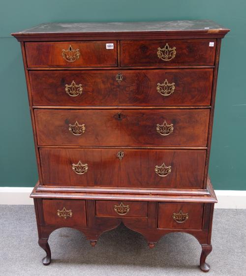 A mid-18th century figured walnut chest on stand, with two short over three long graduated drawers, the base with three frieze drawers, on cabriole su