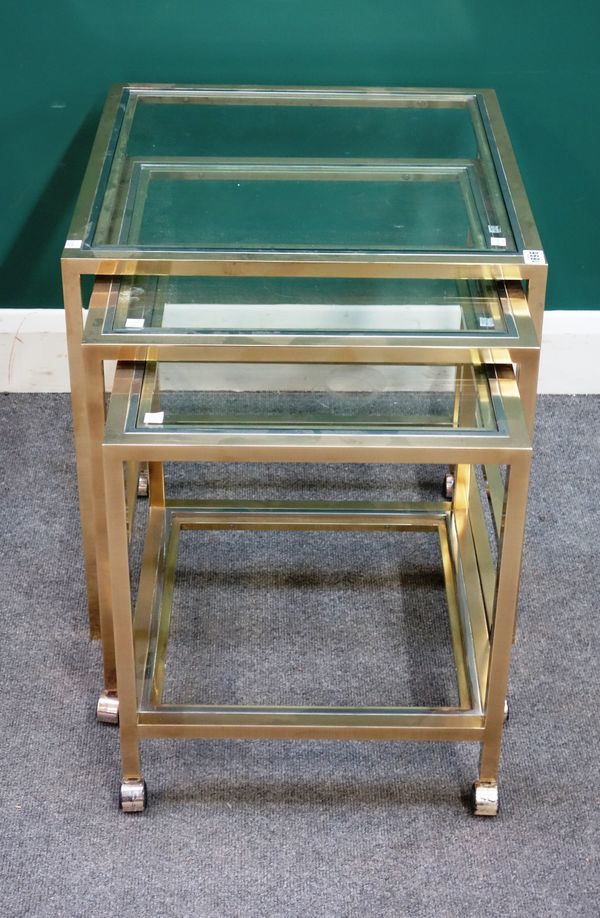 A nest of three graduated lacquered brass square occasional tables, each with two tiered glass inserts, the largest 54cm wide x 55cm high, (3).