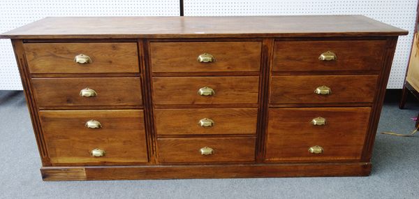 An oak shop fitters unit, with ten various drawers on plinth base, 207cm wide x 90cm high x 57cm deep.