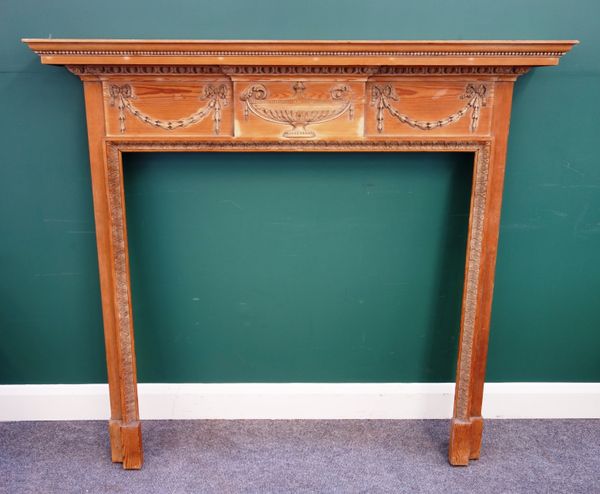 An Adams style pine fire surround, with urn and swag mounted frieze, 143cm wide x 132cm high, the aperture 102cm wide x 103cm high.