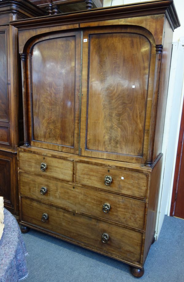 A George IV mahogany linen press, the pair of arch panel doors flanked by columns over two short and two long drawers, 137cm wide x 218cm high x 58cm