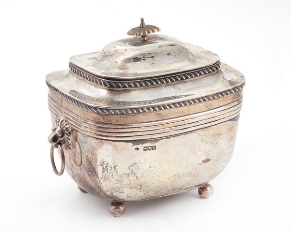 A large late Victorian silver tea caddy, of rounded rectangular form, with a domed hinged lid and twin lion masked ring handles, decorated with gadroo