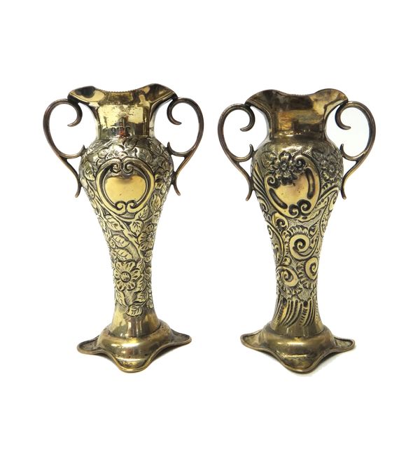 A pair of late Victorian silver posy vases, with twin scroll handles and embossed foliate and scroll decoration, height 13.5cm, combined weight 235 gm