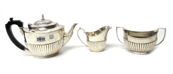 A silver composite three piece tea set, comprising; a teapot, Birmingham 1929, a twin handled sugar bowl, Sheffield 1890 and a milk jug, Sheffield 189