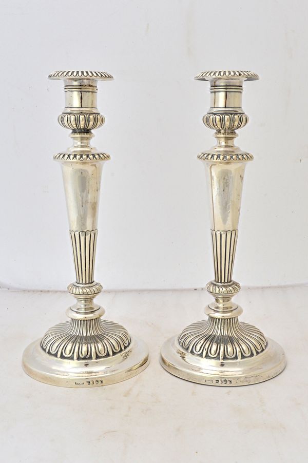 A pair of George III silver table candlesticks, each with a partly fluted tapering column and beaded rims, on a circular base, (loaded), Sheffield 181