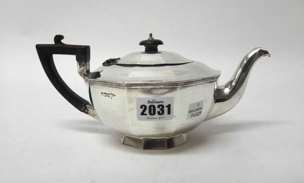 A silver teapot, of multi-sided tapered form, with a decorated rim, black fittings and on a plain foot, by Walker & Hall, Sheffield 1914, gross weight