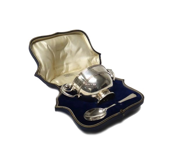 A silver twin handled christening bowl, raised on a circular foot and a silver rat tail pattern christening spoon, by Goldsmiths and Silversmiths Comp