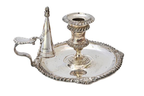 A late Victorian silver chamber candlestick, of shaped circular form, decorated with gadrooned rims and with a snuffing cone fitted to the thumbpiece,