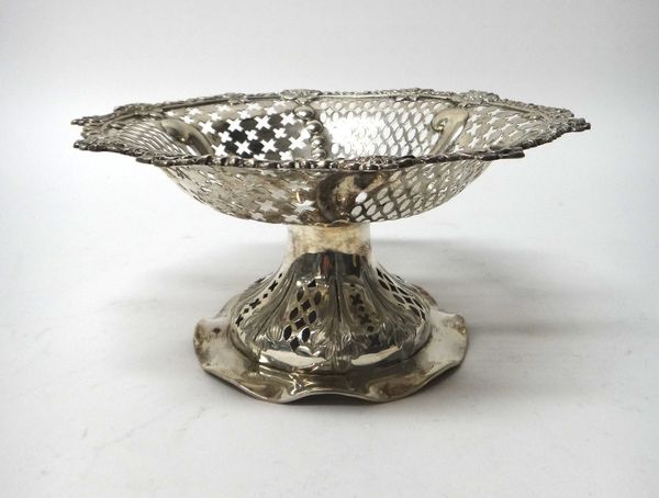 A late Victorian silver tazza, of shaped circular form, having pierced decoration within a cast floral border, raised on a pierced shaped circular foo