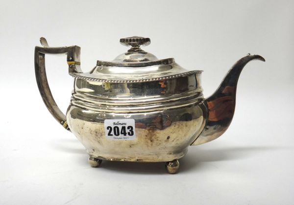 A George III silver teapot, of squat curved form, having a decorated rim, raised on four spherical feet, London 1815, gross weight 602 gms.