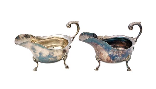 A pair of silver sauceboats, each having a shaped rim, scrolling handle and raised on three hoof shaped feet, London 1938, combined weight 268 gms, (p