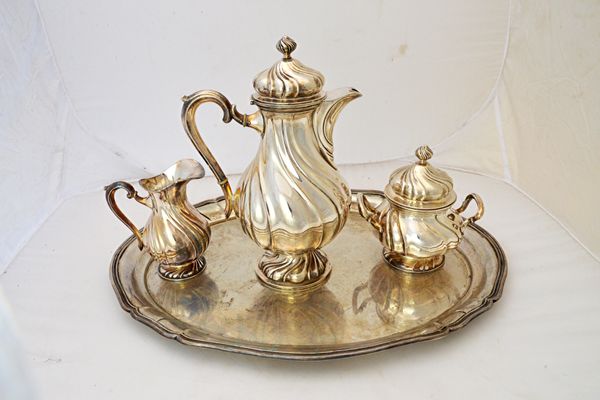 A German four piece part tea set, comprising; a shaped oval tray, length 49.5cm, a hot water jug, a twin handled sugar bowl and cover and a milk jug,