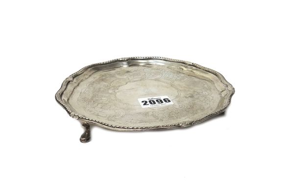 An Irish silver waiter, of shaped circular form, the centre with later floral and foliate engraved decoration, crest engraved, the shaped rim with a b