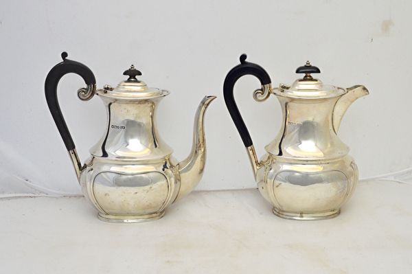 A silver coffee pot, with a matching silver hot water jug, each piece of curved baluster form, with a shaped lower part to the body and with black fit