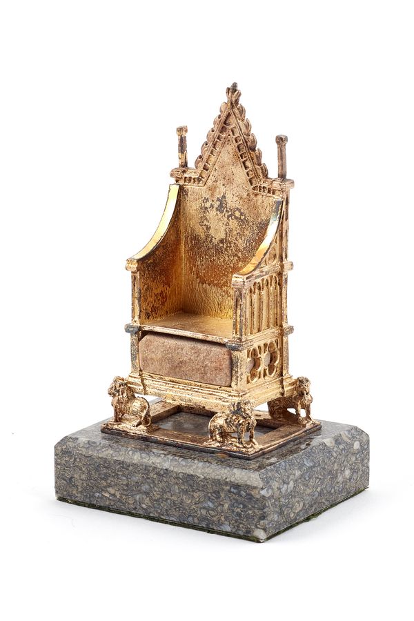 A silver gilt model of The Coronation Chair, incorporating a model of the Stone of Scone, mounted to a rectangular grey marble base, height 14.5cm, Bi