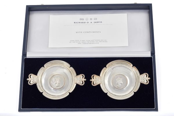 A pair of silver twin handled shaped circular dishes, commemorating fifty years since the coronation of Elizabeth II, each shaped circular bowl mounte