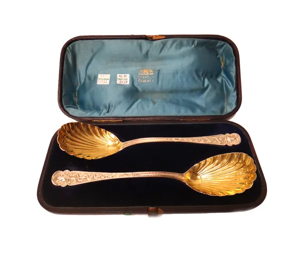 A pair of silver dessert serving spoons, the scalloped bowls with gilded decoration, the handles decorated with serpents and frogs, as later converted