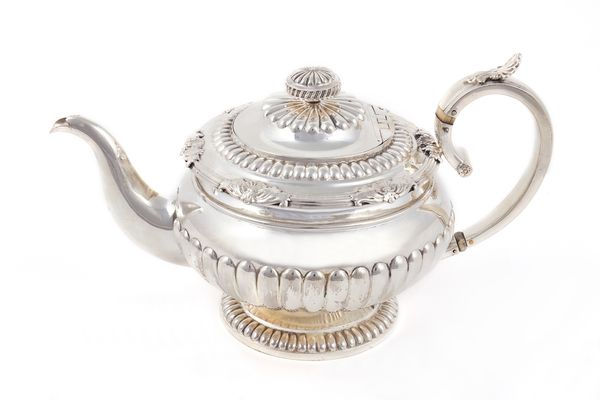 A George III Scottish silver teapot, of squat circular form, the body, the foot and the lid with partly fluted decoration, the lid with an associated
