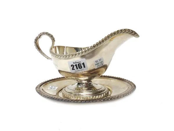 A silver sauceboat, with a shaped handle and gadrooned decoration to the rims, with an associated silver oval stand, similarly decorated to the rim, b