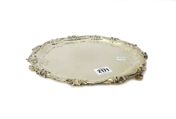 A silver salver, of shaped circular form, in the Chippendale style, decorated with floral motifs to the border, raised on three scrolled feet, by Gold