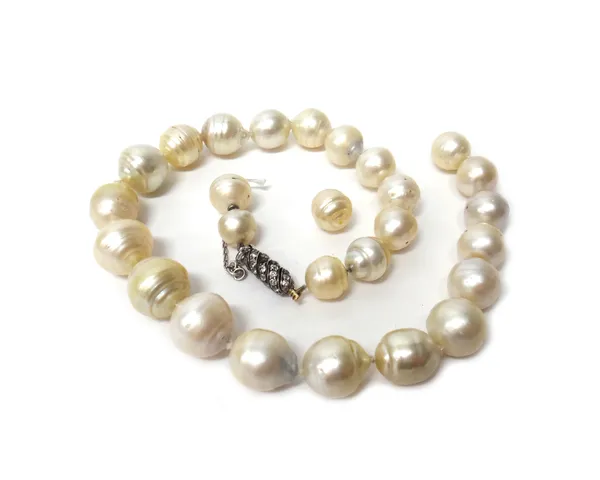 A single row necklace of graduated baroque cultured pearls, on a diamond set clasp of spiral design, two cushion shaped diamonds lacking, thread broke