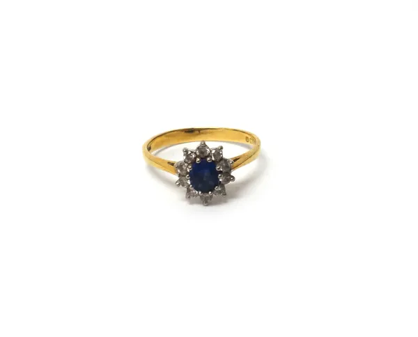 An 18ct gold, sapphire and diamond oval cluster ring, claw set, with the oval cut sapphire at the centre, in a surround of ten circular cut diamonds,