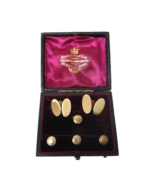 A pair of gold cufflinks, with plain oval backs and fronts, detailed 15 CT, combined weight 12.5 gms and a set of three small and one larger dress stu
