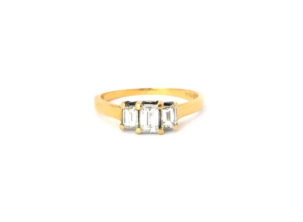 An 18ct gold and diamond three stone ring, mounted with a row of millennium cut diamonds and with the principle diamond mounted at the centre, Birming